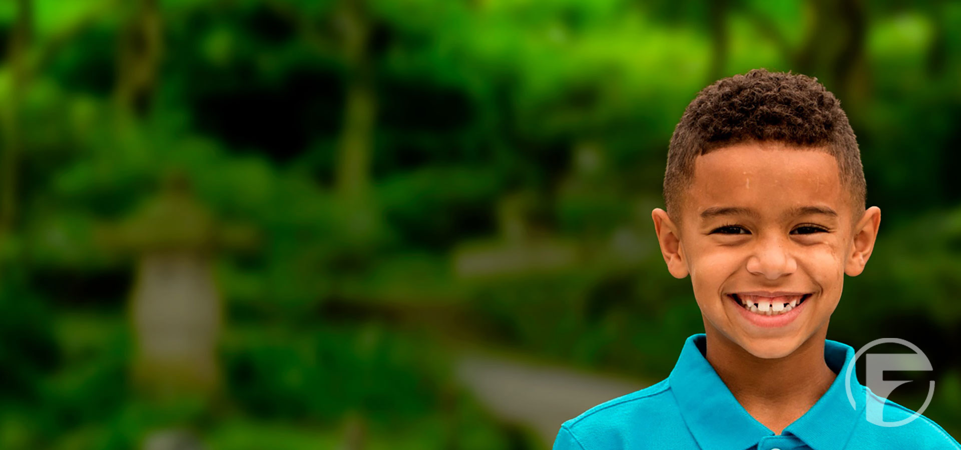 A child smiling outdoors, representing the communities supported by the Figgers Foundation.