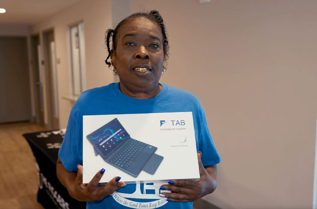 A resident holding a Florida Connect tablet indoors.