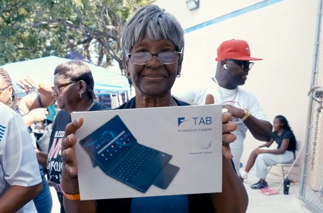 A senior holding a Figgers tablet at a neighborhood event.